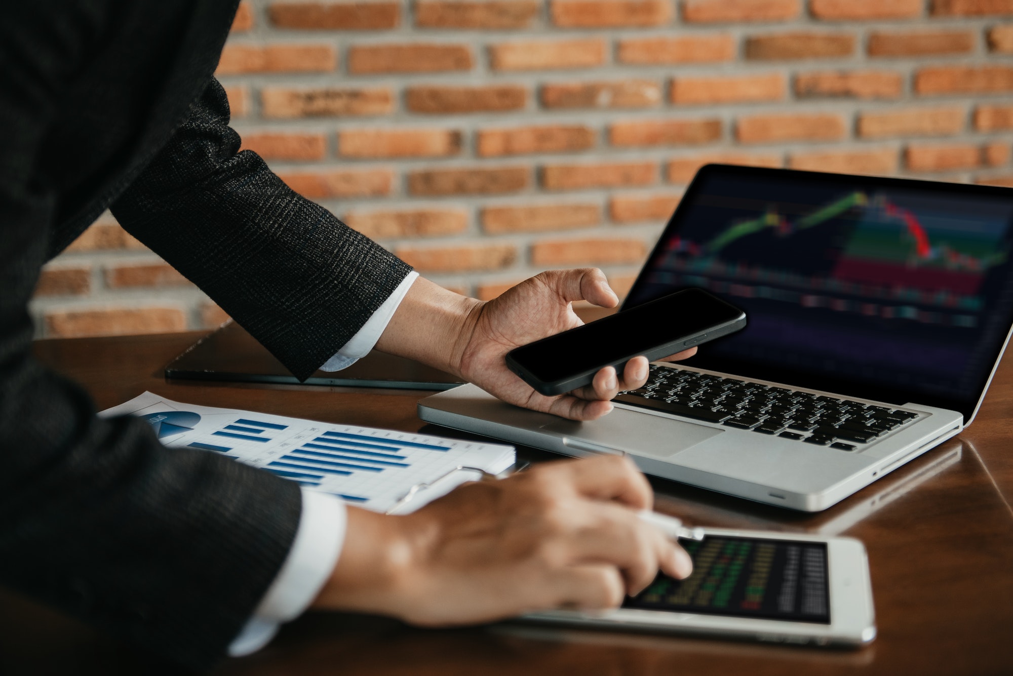 Trader using a phone and laptop